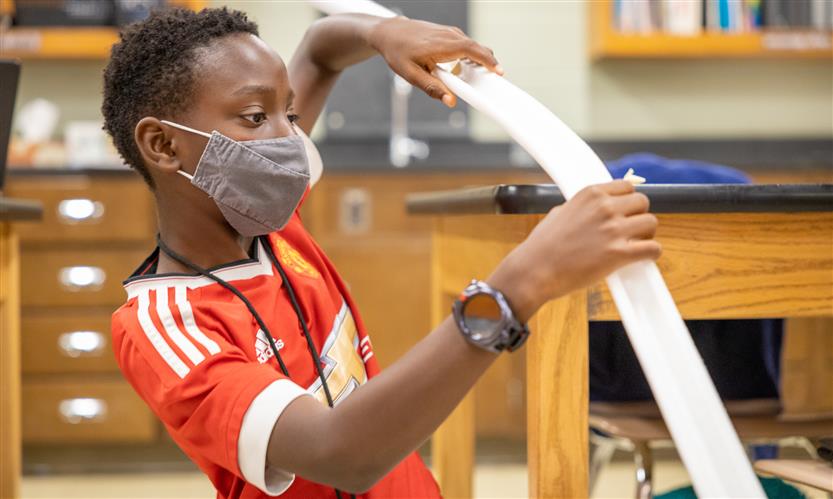 A boy works on a mini rollercoaster track
